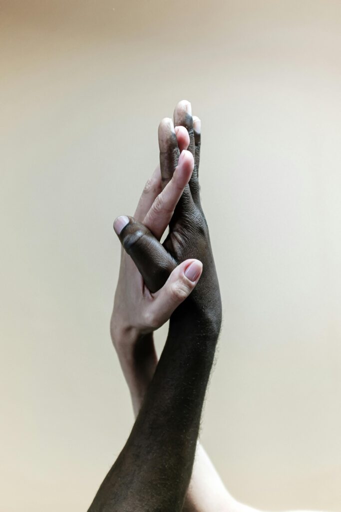Close-up of diverse hands clasped together, representing unity, support, and diversity.